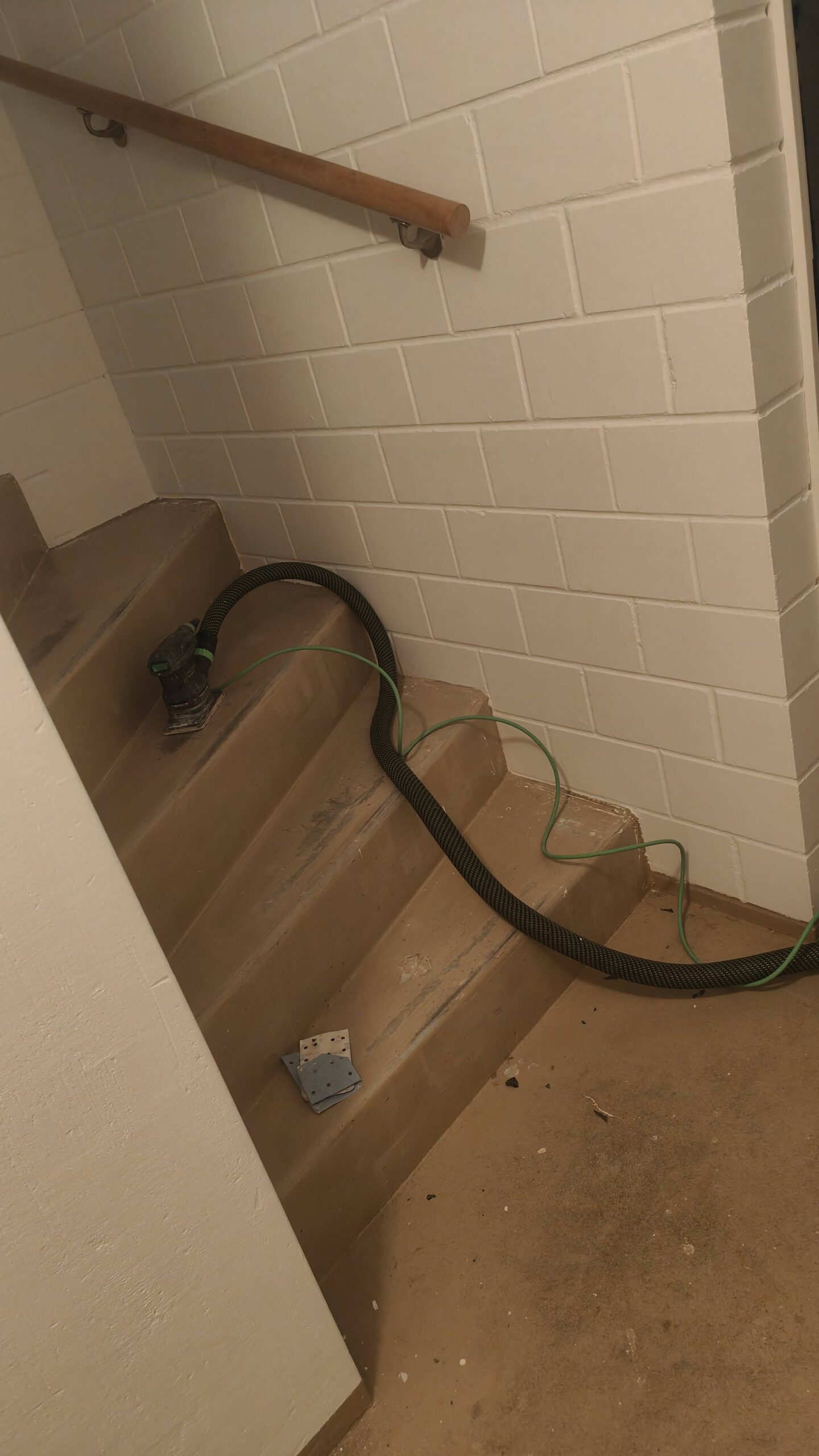 Treppensanierung: Schleifarbeiten an einer Treppe im Gang